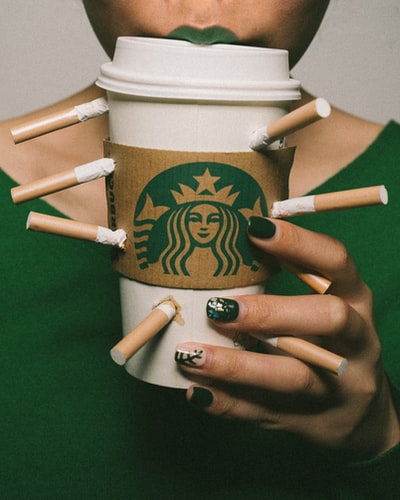 白色星巴克咖啡杯，四周环绕着香烟